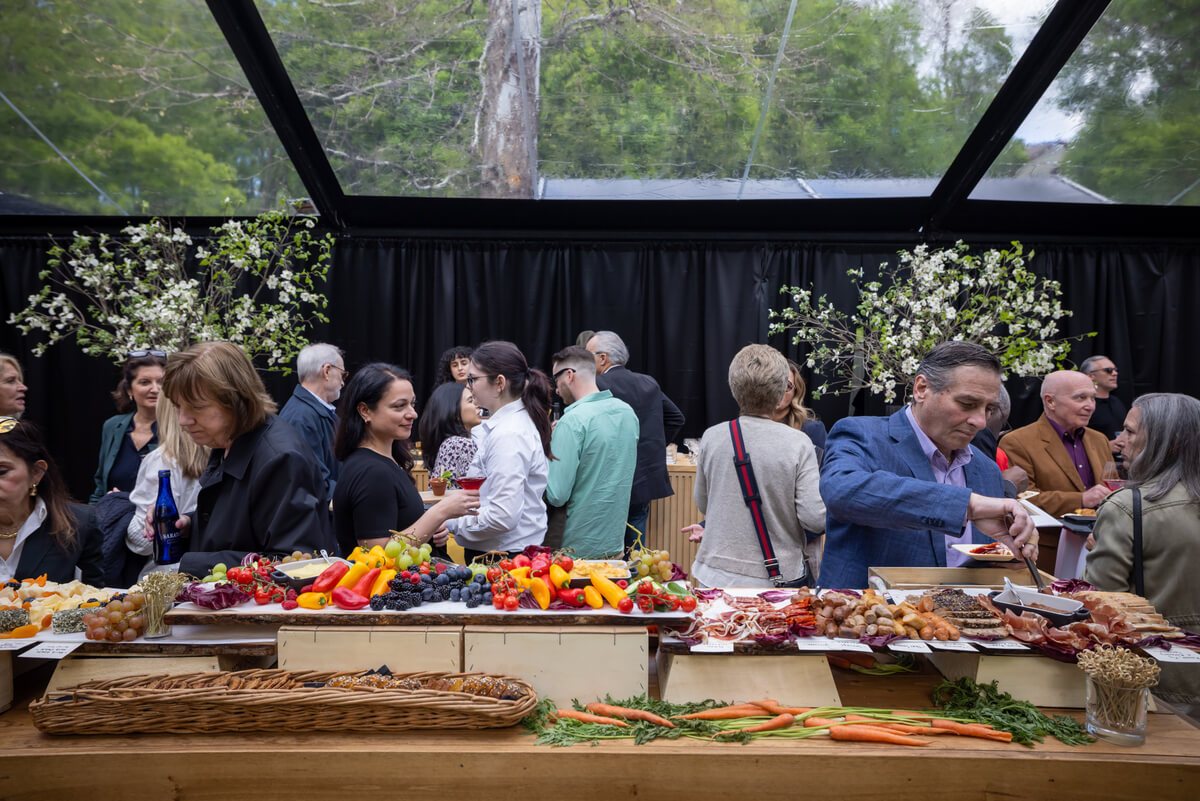 Guests gathered around a long harvest table in the pavilion