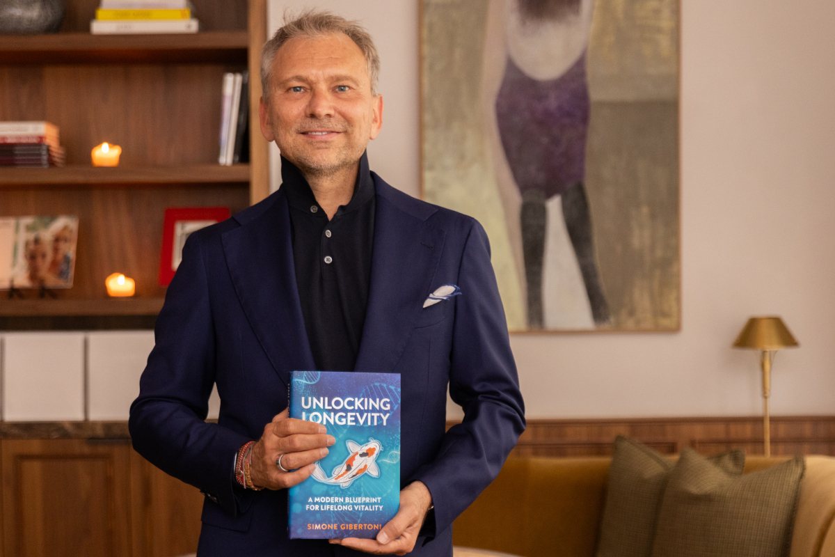 A speaker holding a book on longevity